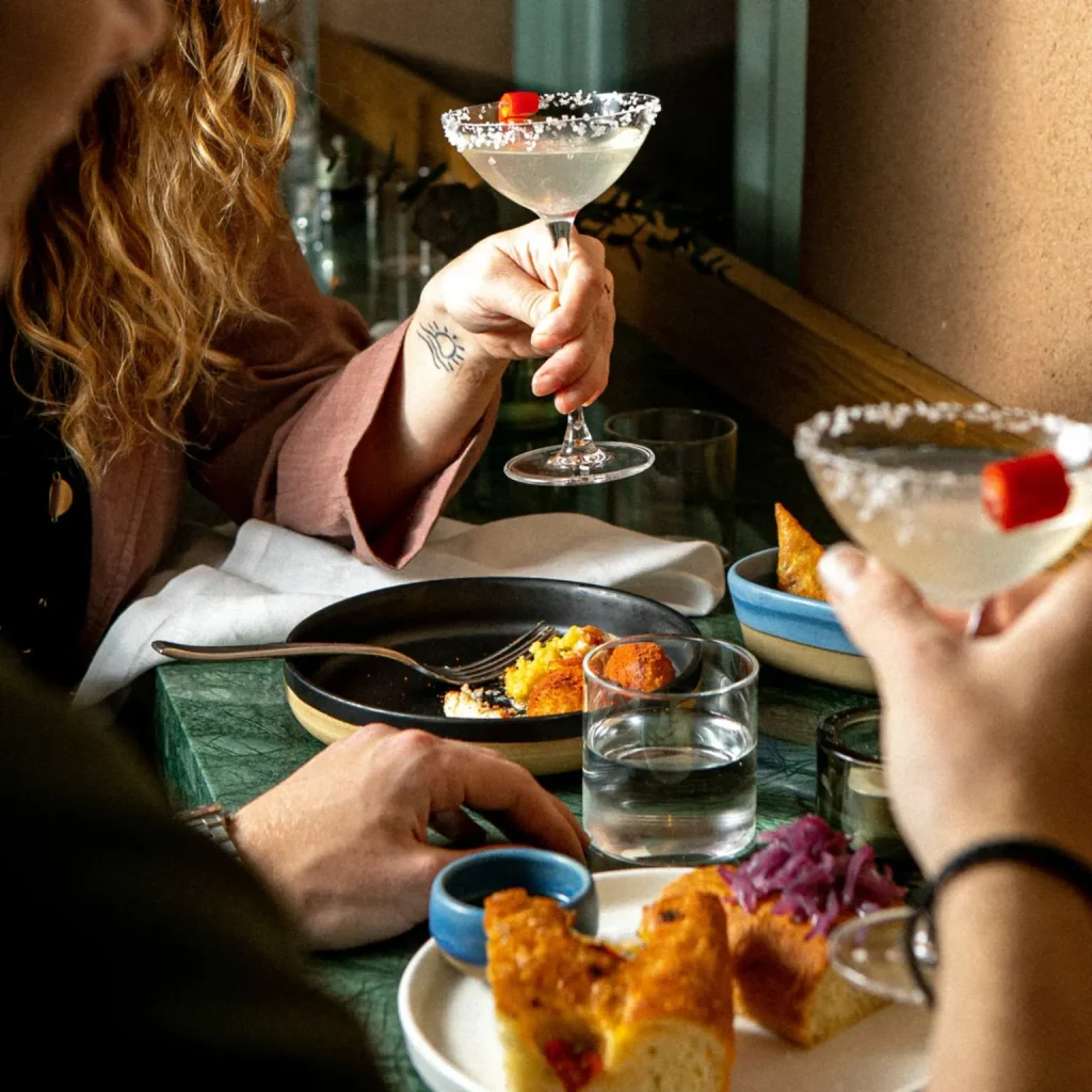 Two people enjoying cocktails and nibbles